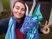 Photo of the artist with a blue soft-sculpture dragon