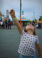 Photo of a girl making a triumphant fist at a county fair.