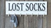 Photo of a painted wall sign with clothespins for lost socks.