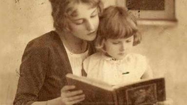 Vintage photo of a mother reading a book with her daughter.