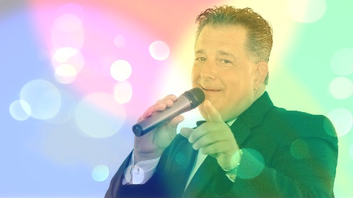 Jim Bulanda posing in tux with microphone